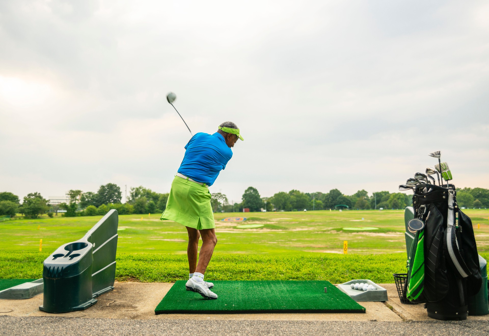 The active, optimistic 77-years-old senior Black woman playing golf